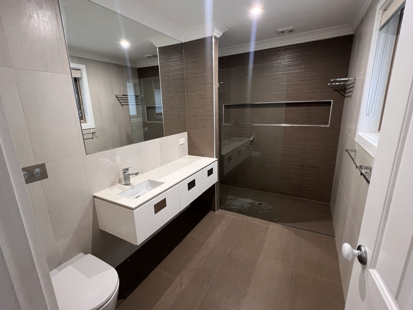 Ensuite before renovation, with dark brown tiles